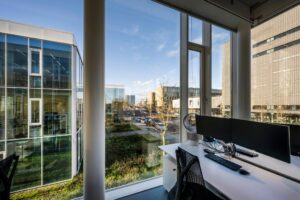 Kantoorruimte met werkplek en uitzicht op de Fred. Roeskestraat in Amsterdam, omringd door moderne kantoorgebouwen.